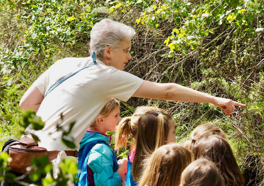 woman pointing out plants to children