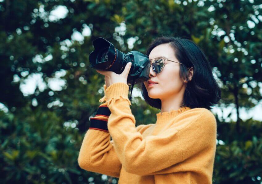 woman taking photo in forest